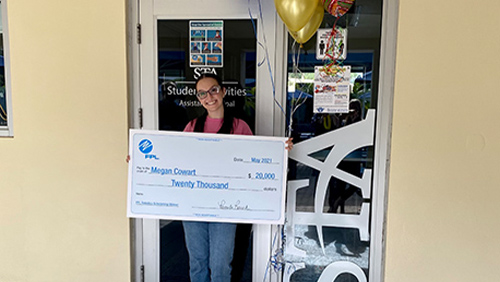 robotics scholarship winner megan cowart holding a big check