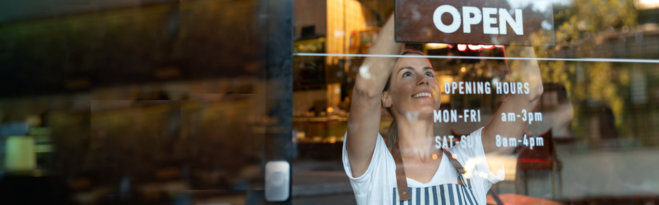 employee hanging an open sign
