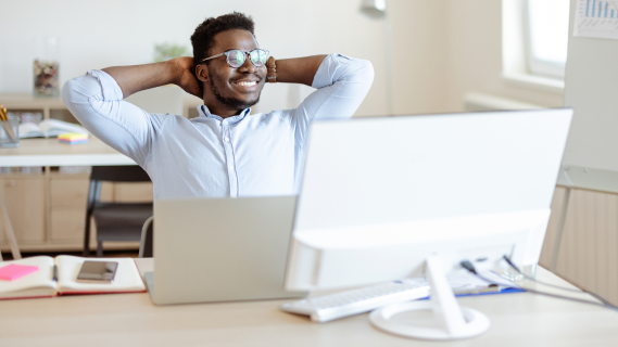 man sitting at desk with computer in front of him