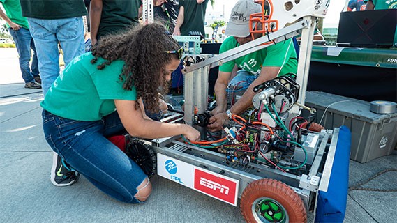 two people working on a robot at fau robotics event