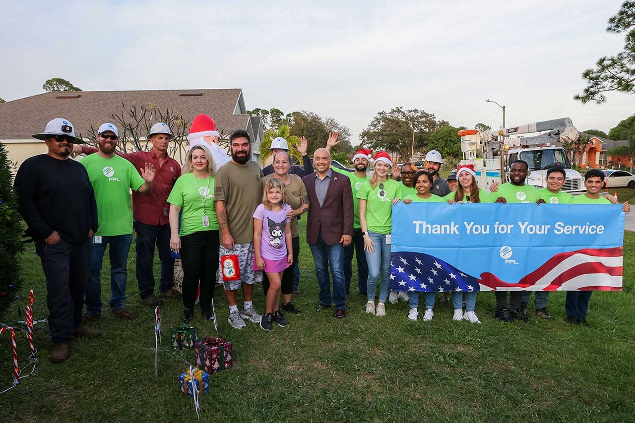 Holiday hero lighting - veteran, family and fpl employees with a banner that says "thank you for your service"