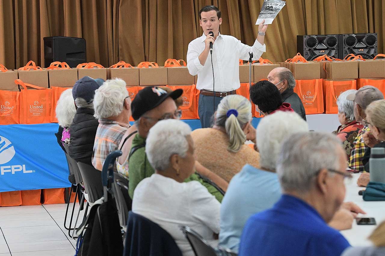 Senior citizens receiving hurricane meal kits from FPL employees.
