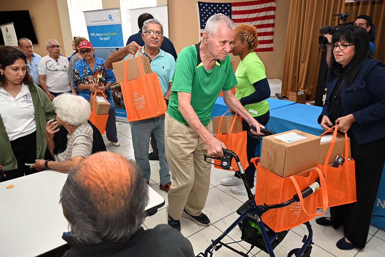 Senior citizens receiving hurricane meal kits from FPL employees.