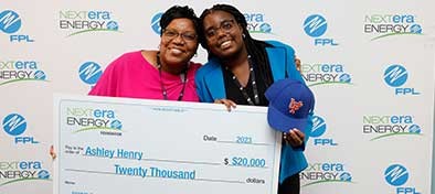 Teacher holding giant check for $20,000