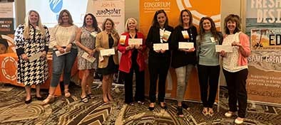 Teachers holding checks from donation