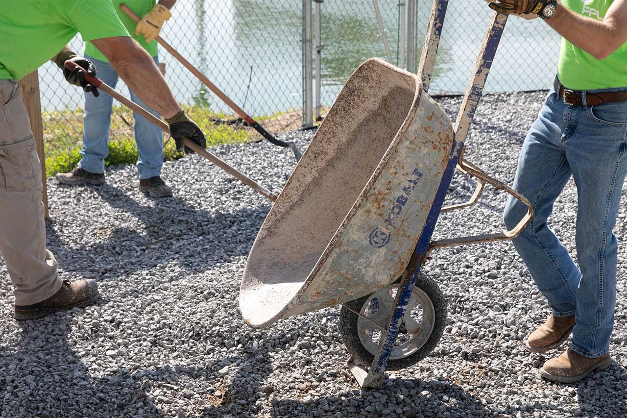 Volunteers shoveling rocks and dirt