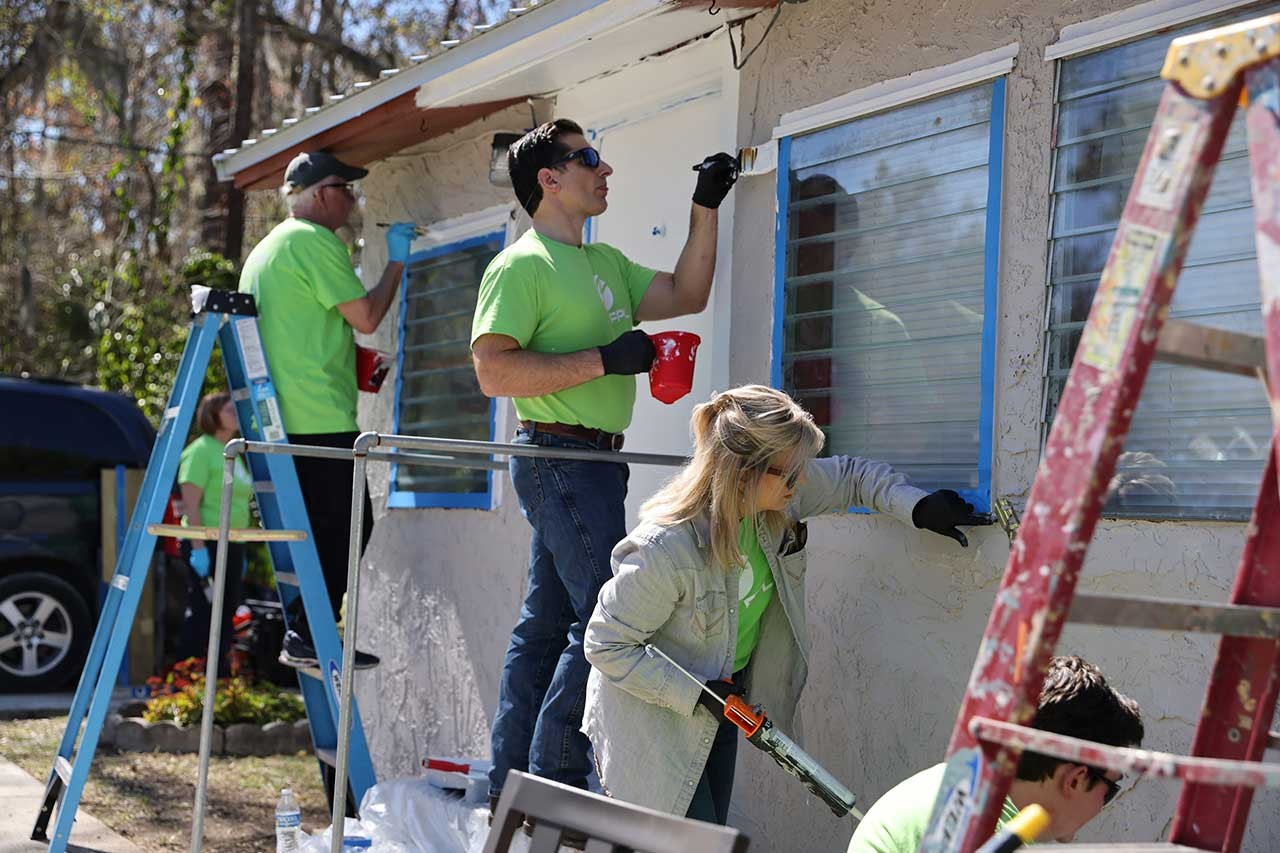 Volunteers painting a house