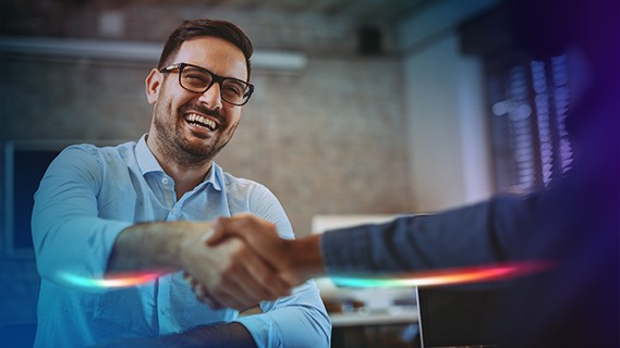 a man smiling and shaking hands with a colleague