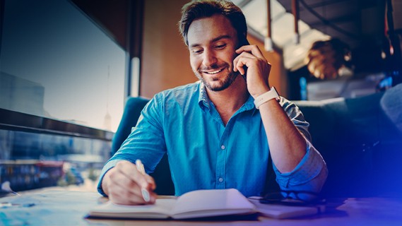 a man on a phone call taking notes