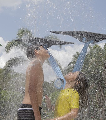 kids enjoying splash pad with a solar tree in the background