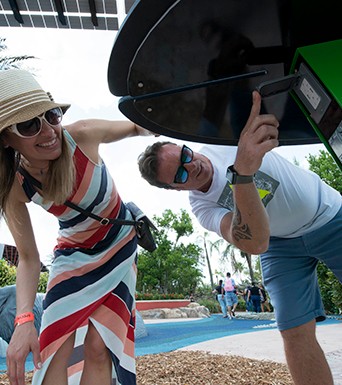 couple at miami zoo using charger on solar tree