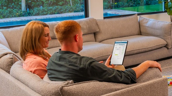 Couple sitting on the couch looking at iPad