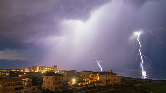 Lighting strikes in two locations in the distance over the skyline