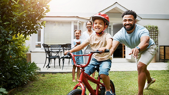 family in backyard with boy riding bike
