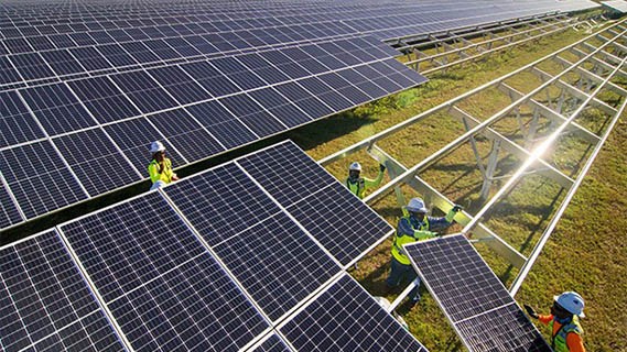 aerial view of fpl workers assembling solar panels in a large field