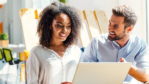 Man and woman on laptop laughing together