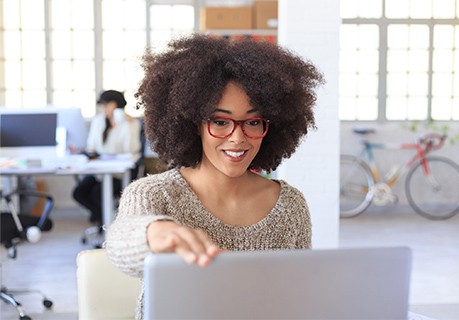 Woman smiling at her computer screen