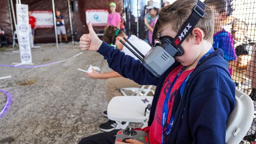 kid wearing virtual reality goggles and giving a thumbs up 