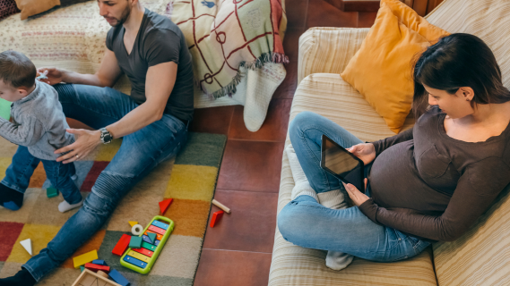 pregnant mother relaxing on couch with father and son nearby