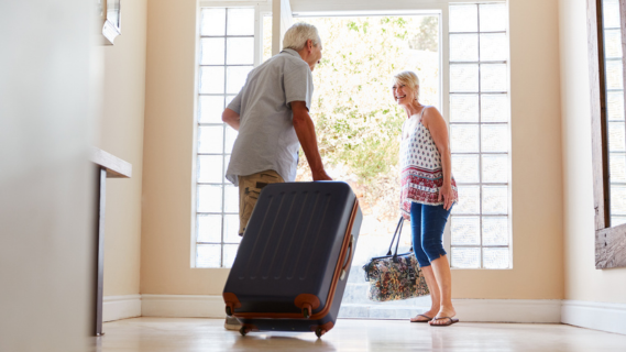 man and woman leaving home with suitcases