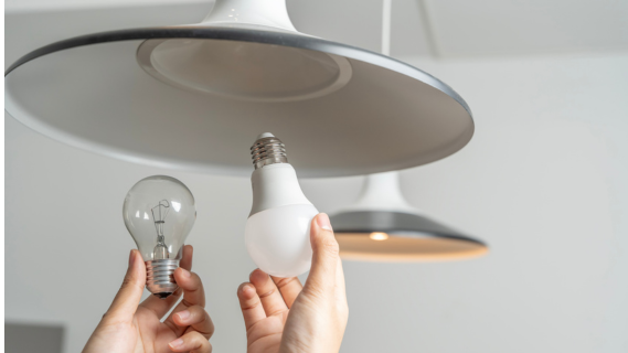 hand installing lightbulb into fixture