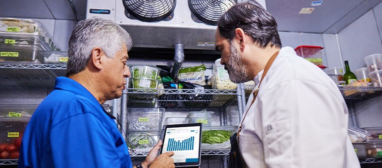 an fpl energy expert viewing a restaurant owner's energy usage in walk-in refrigerator