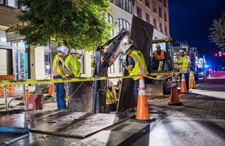 Crews working underground in downtown Pensacola at night