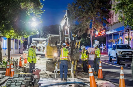 Crews working underground in downtown Pensacola at night