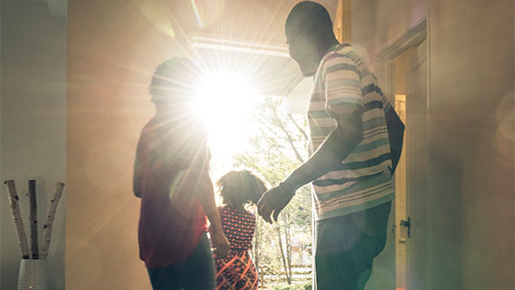 a family walking out the door of their home letting in sunlight