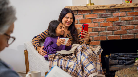 Mother and child sitting by fireplace