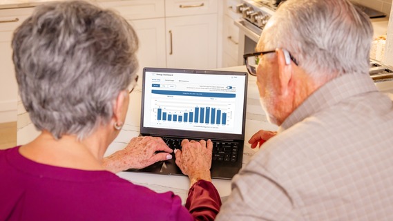 Elderly couple looking at their energy dashboard on the kitchen counter