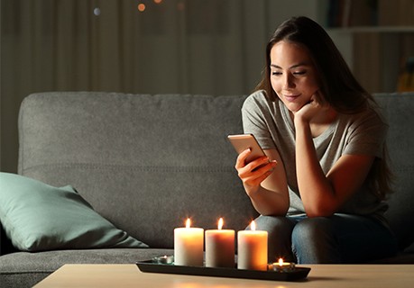 Woman sitting on couch using mobile device