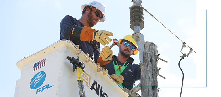 two fpl linemen in a bucket truck assessing a powerline