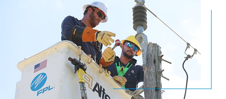 two fpl linemen in a bucket truck assessing a powerline