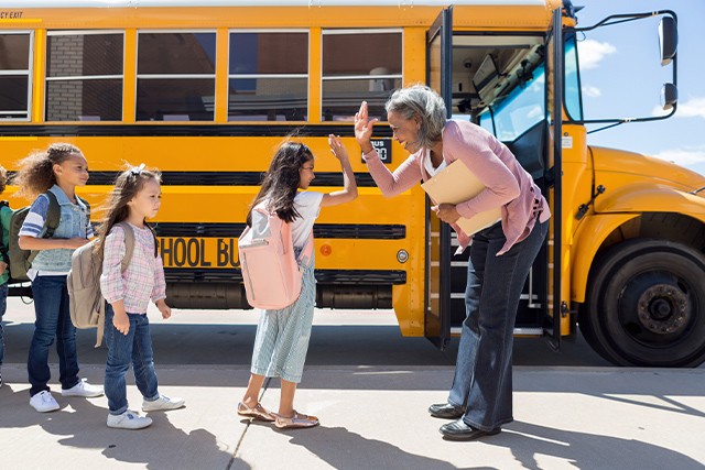 children in front of school bus having fun