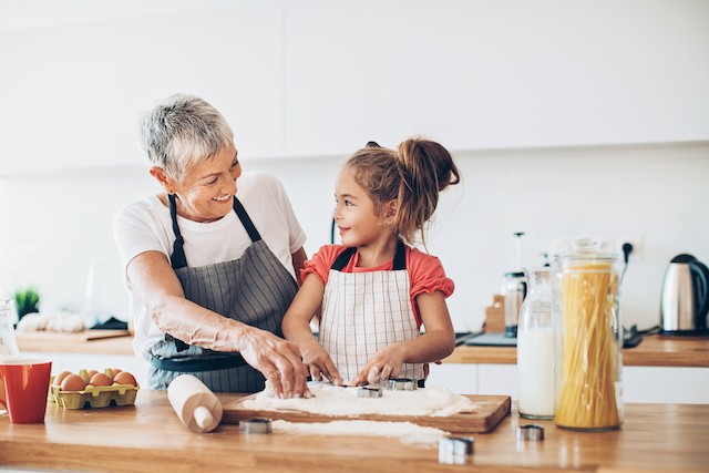 Senior woman and a small girl preparing cookies