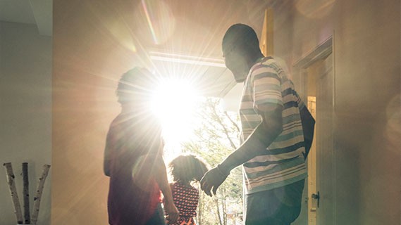 a family walking out their front door letting in sunlight