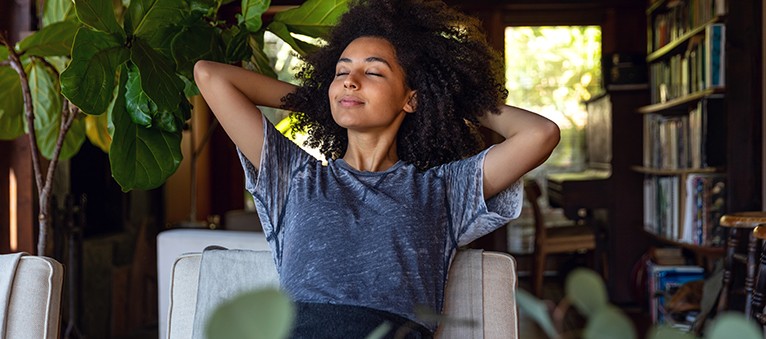 woman smiling with her hands behind her head