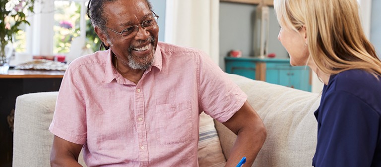 two senior citizens chatting on couch